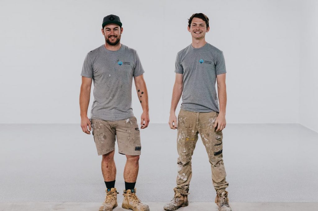 Two team members of Complete Coatings on gray background